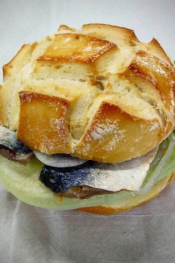 Fischbrötchen é um sanduíche de peixe, muito comum no norte da Alemanha. Aqui montado com cavalinha crua em conserva, cebola, alface e creme azedo.
